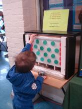 A younger visitor feeding coins into our new 'FUN WHILE YOU GIVE' donation box!